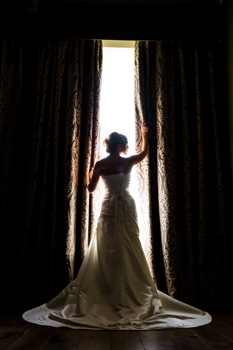 Bride window pose, bridal gown exposure