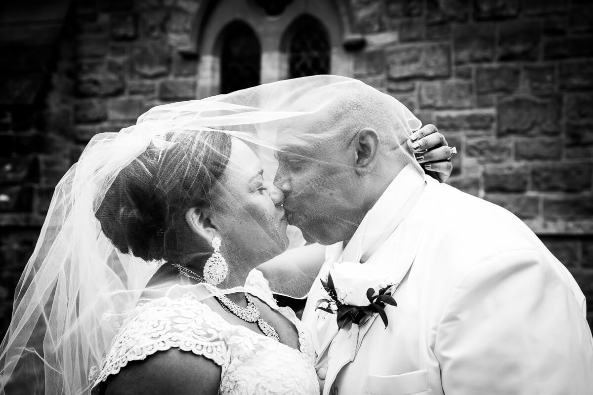 Outside the chapel bride groom veiled kiss